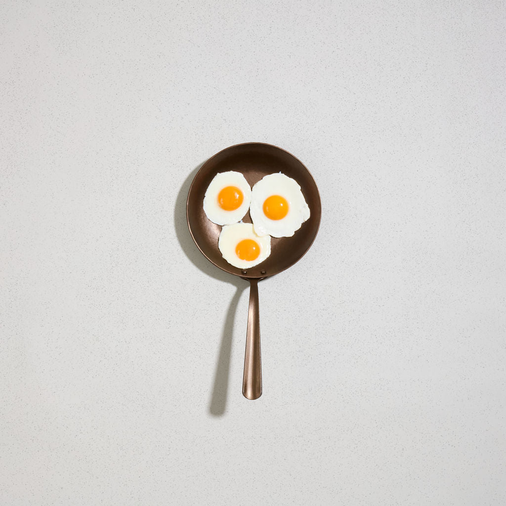 Three fried eggs in a Little Farmhouse Skillet, viewed from above
