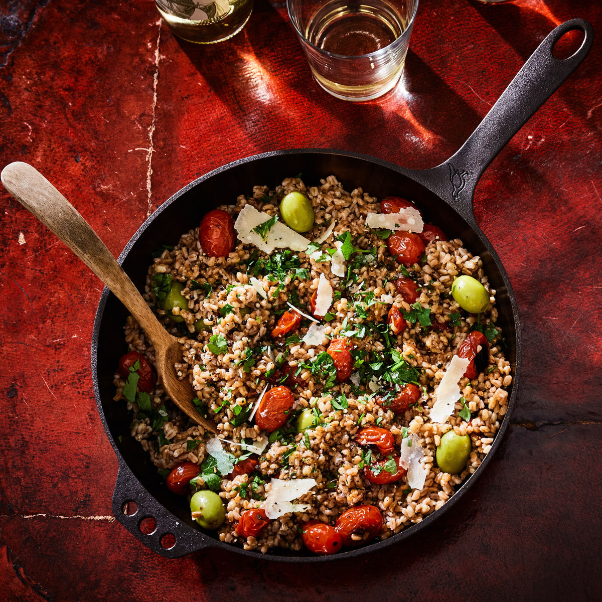 Grain salad with tomatoes and olives in a No. 11 Deep Skillet on a red tile table