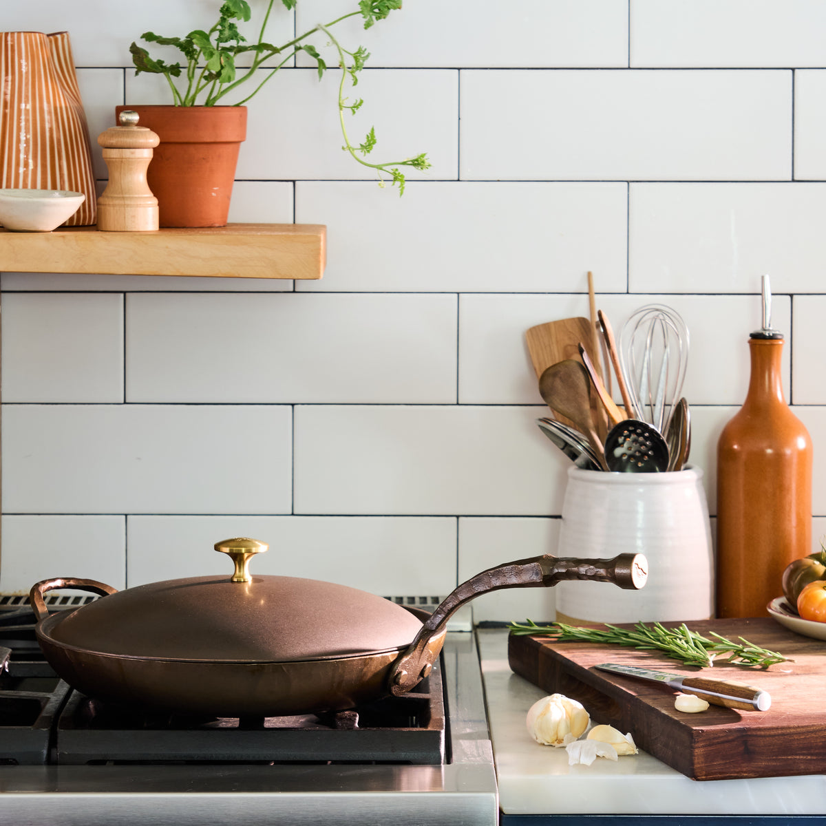 The Carbon Steel Lid on a skillet atop a gas stove in a white-tiled kitchen