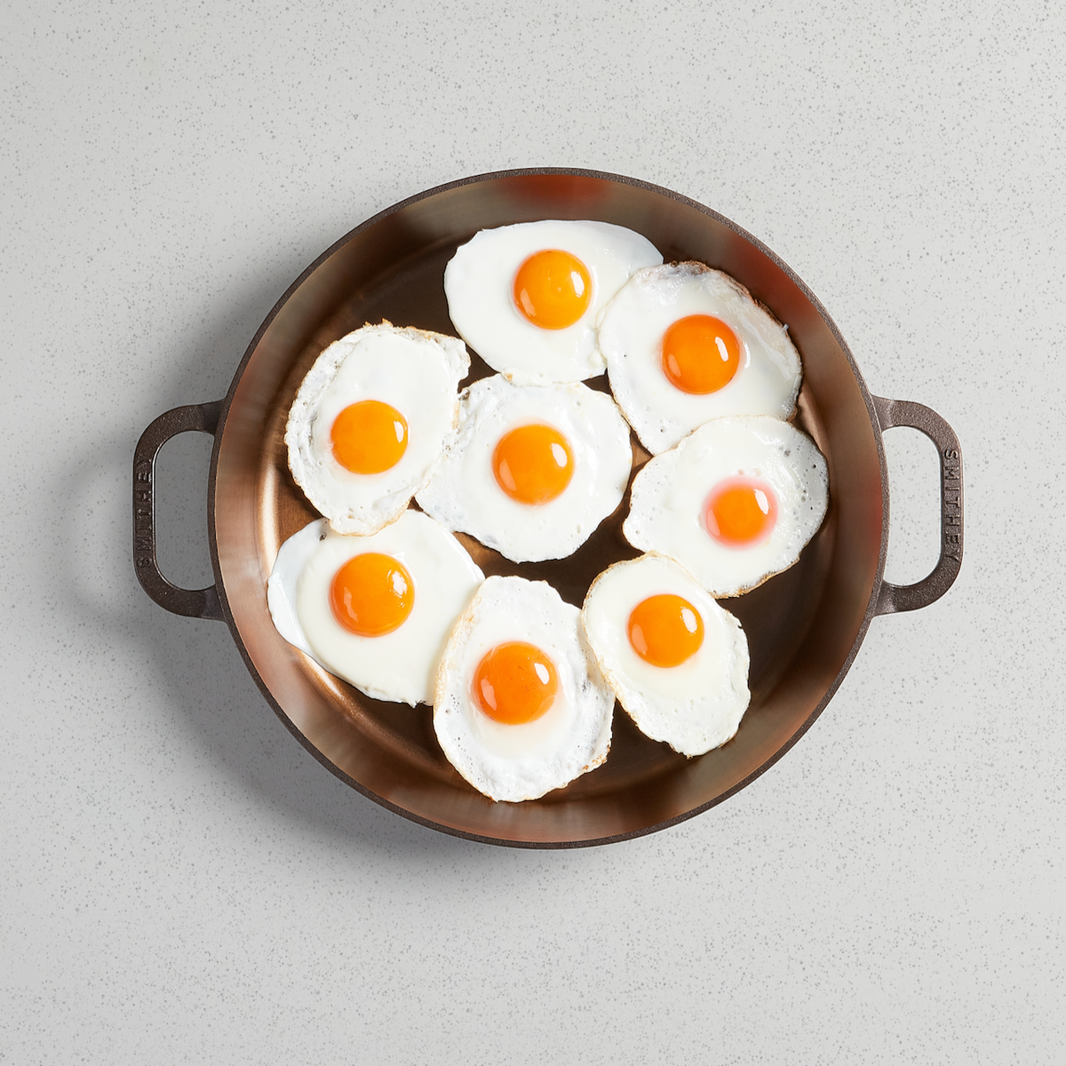 Fried eggs filling a No. 14 Dual Handle Skillet, viewed from above