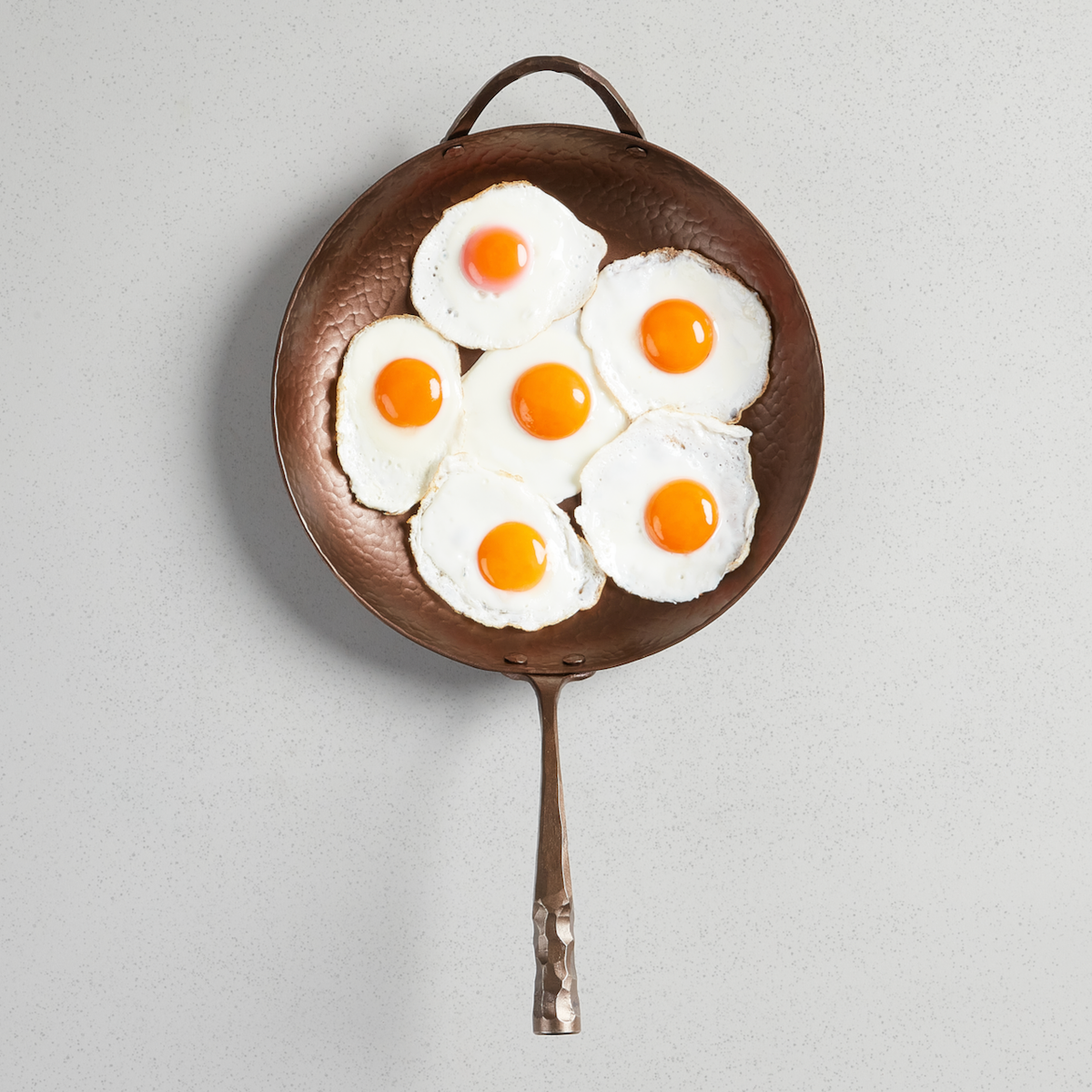Fried eggs filling a Deep Farmhouse Skillet, viewed from above