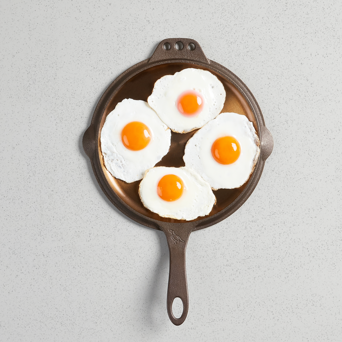 Five fried eggs on a No. 10 Flat Top Griddle, viewed from above