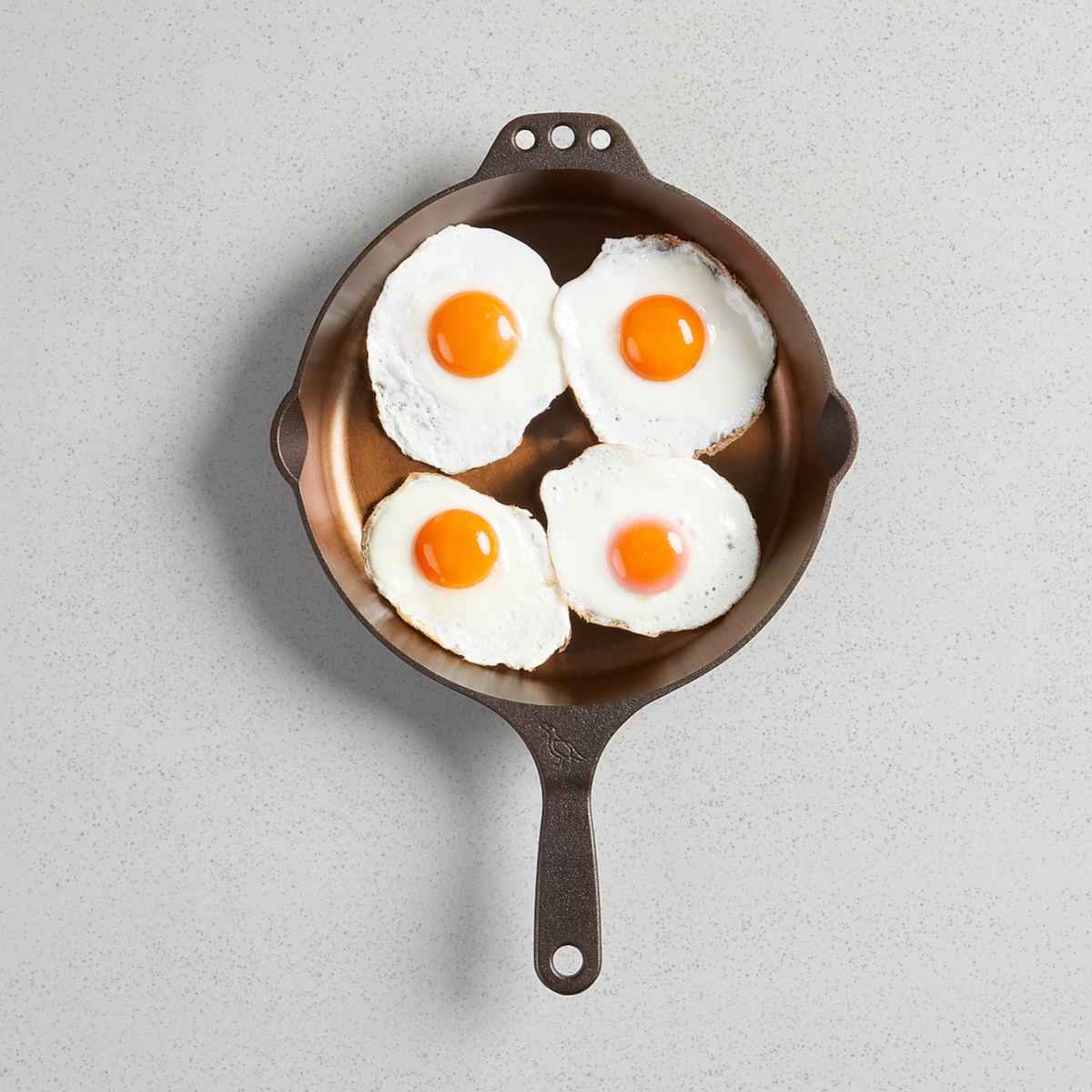 Four fried eggs in a No. 10 Skillet, viewed from above