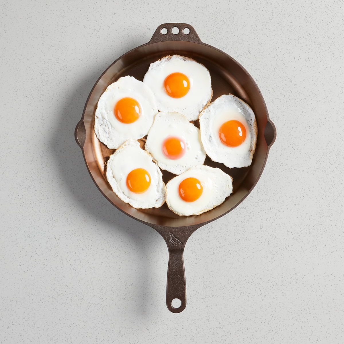Seven fried eggs in a No. 12 Skillet, viewed from above