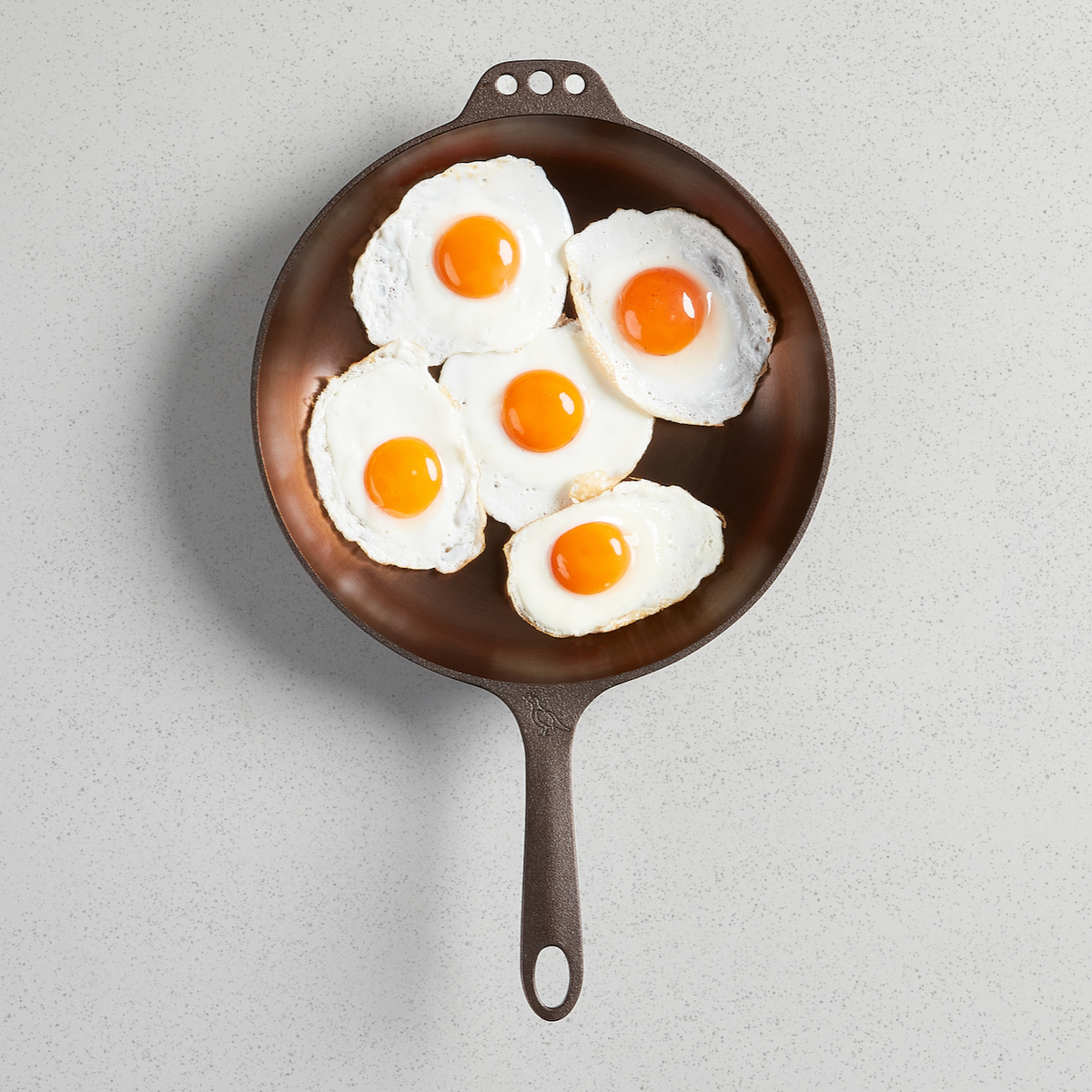 Five fried eggs in a No. 11 Deep Skillet, viewed from above
