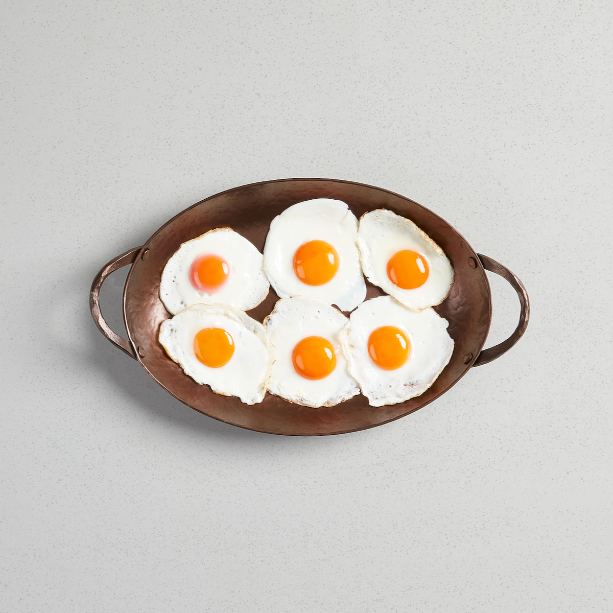 Fried eggs filling an Oval Roaster, viewed from above